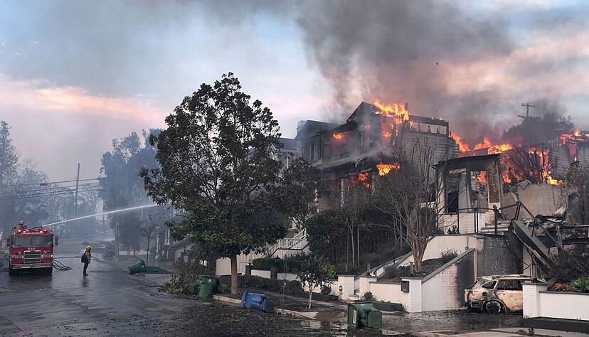 Feuerwehrleute arbeiten in Los Angeles daran, einen Hausbrand zu löschen.