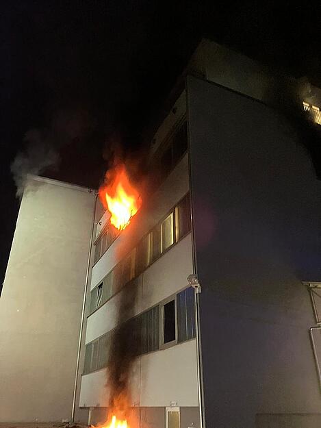 Flammen schlagen beim Eintreffen der Feuerwehr aus einem Fenster des Gebäudes in Böckingen.