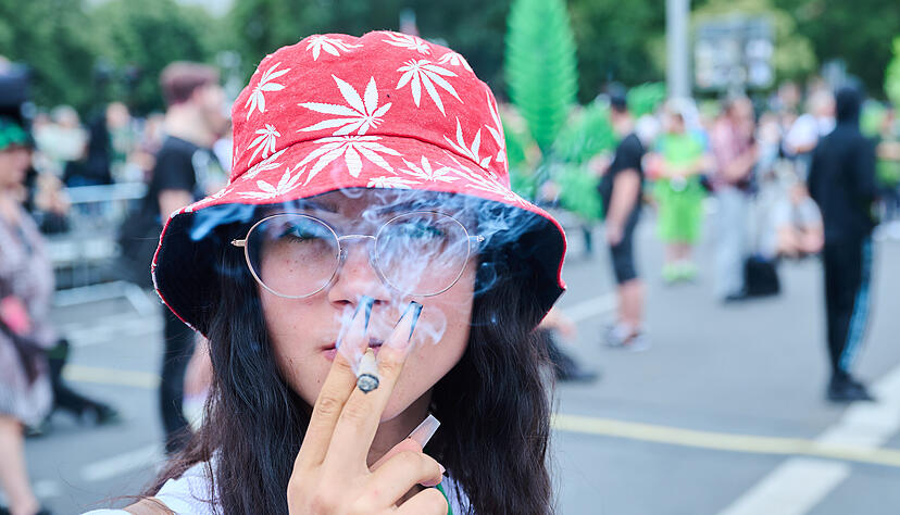Eine junge Frau raucht einen Joint auf der Hanfparade in Berlin.