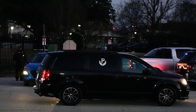 Der Hingerichtete wird in einem Leichenwagen weggefahren.