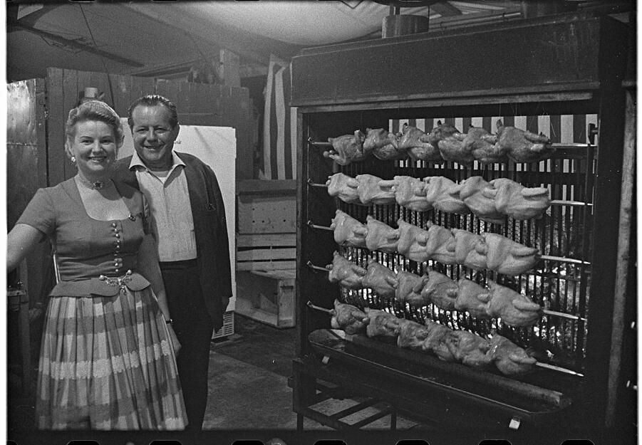 Göckele gehören dazu. 1955 übernimmt Göckelesmaier den Festplatz als Generalpächter, unterstützt vom Schausteller Erich Grund. Im Bild stehen Josefine und Karl Maier neben dem Grill. Die Aufnahme ist mit 1964 datiert.