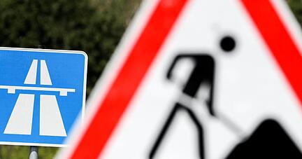 Ein Schild weist auf eine Baustelle auf einer Autobahn hin. Ein Schild weist auf eine Baustelle auf einer Autobahn hin.