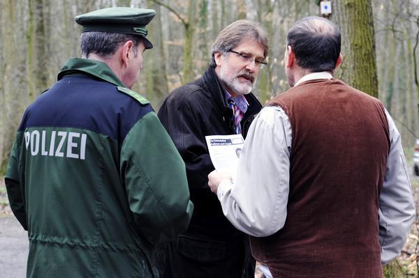 Polizisten befragen Passanten, die den Tatort passieren.