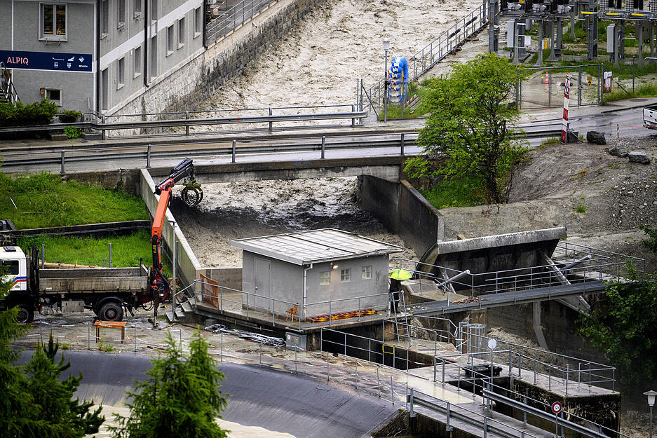 Bagger arbeiten im Val d'Anniviers am Ufer des Hochwasser führenden Flusses Navisence in der Nähe des Alpiq-Wasserkraftwerks. Bagger arbeiten im Val d'Anniviers am Ufer des Hochwasser führenden Flusses Navisence in der Nähe des Alpiq-Wasserkraftwerks.