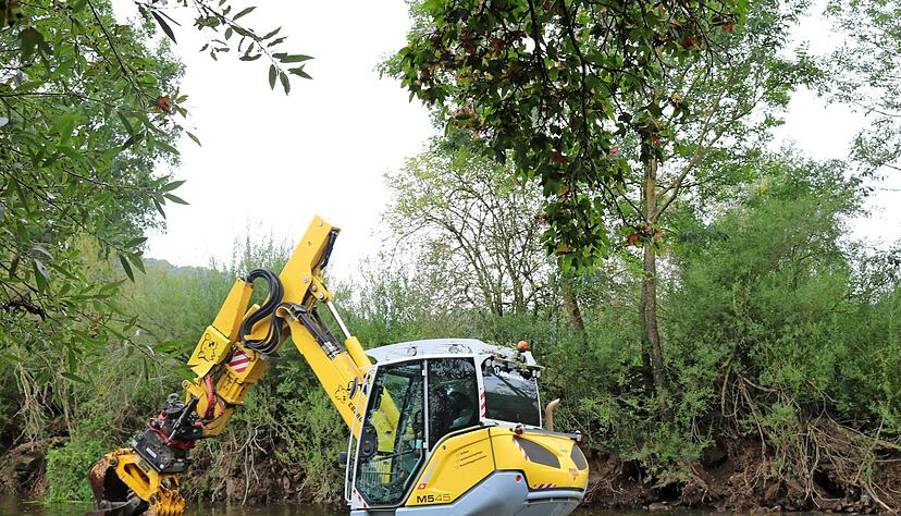 Der Bagger muss durchs tiefe Wasser, um Steine und Pflanzen umzusetzen. Die Steine klopft er mit einem Sto&szlig; fest, denn sie sollen nicht im Flussbeet herumrollen, sondern die Jagst in Schwung bringen.
Fotos: Nadine Nowara