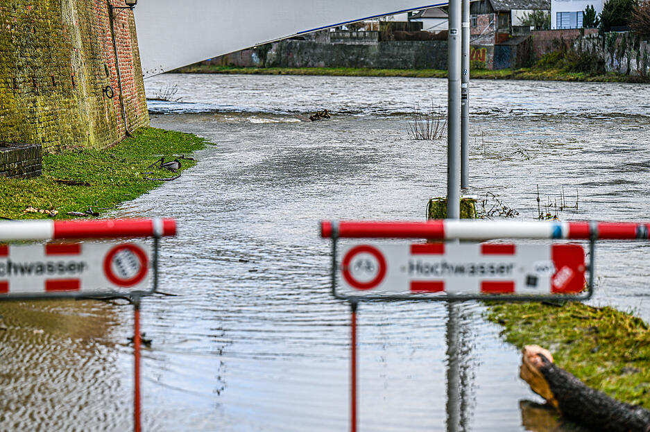 Ein Schild mit der Aufschrift "Hochwasser" steht an der Donau. Die Niederschläge und der schmelzende Schnee der vergangenen Tage hat den Pegel mehrerer Flüsse im Südwesten anschwellen lassen. In Ulm ist der Radweg gesperrt.