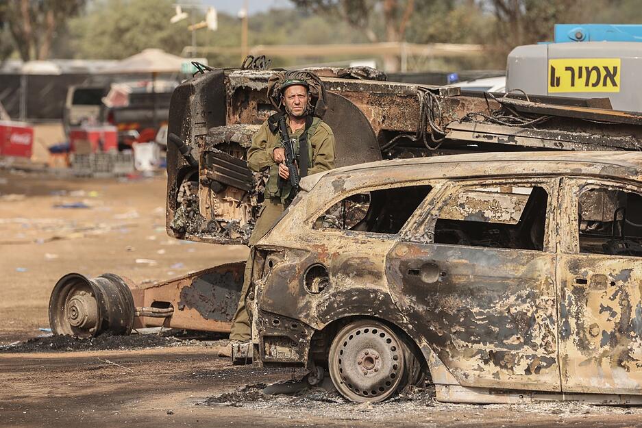 Ein israelischer Soldat steht auf dem Gelände des elektronischen Musikfestivals Supernova nach dem tödlichen Angriff islamistischer Hamas-Kämpfer vom 07.10.2023, bei dem 260 Menschen starben und mehr als 100 Menschen als Geiseln genommen wurden.