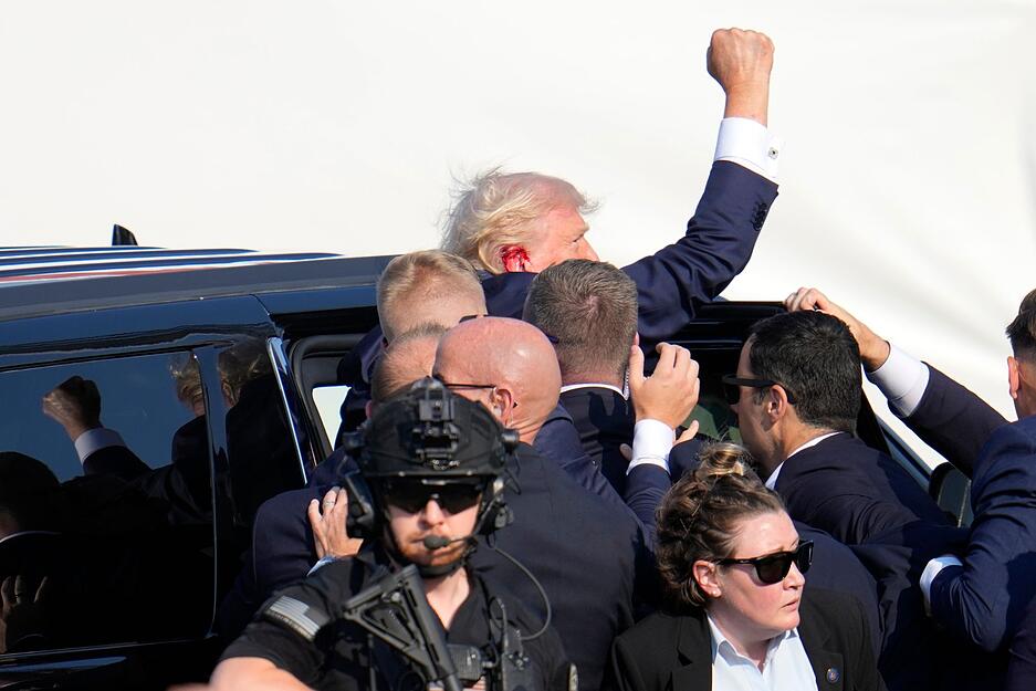 Sicherheitspersonal bringt Donald Trump nach dem versuchten Attentat in ein Auto.