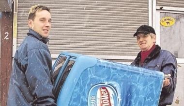 Zwei Arbeiter tragen die Eistruhe weg. Sie wird nicht mehr gebraucht. Zwei Arbeiter tragen die Eistruhe weg. Sie wird nicht mehr gebraucht.