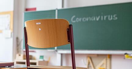 «Coronavirus» steht auf einer Tafel in einem leeren Klassenzimmer.