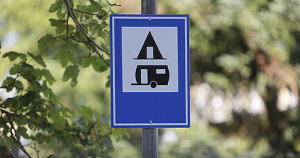 Blick auf ein Hinweisschild auf einen Campingplatz. Nach herben Einschnitten während der Pandemie erwacht der Tourismus auch in Sachsen-Anhalt mit den Lockerungen zum Leben. +++ dpa-Bildfunk +++