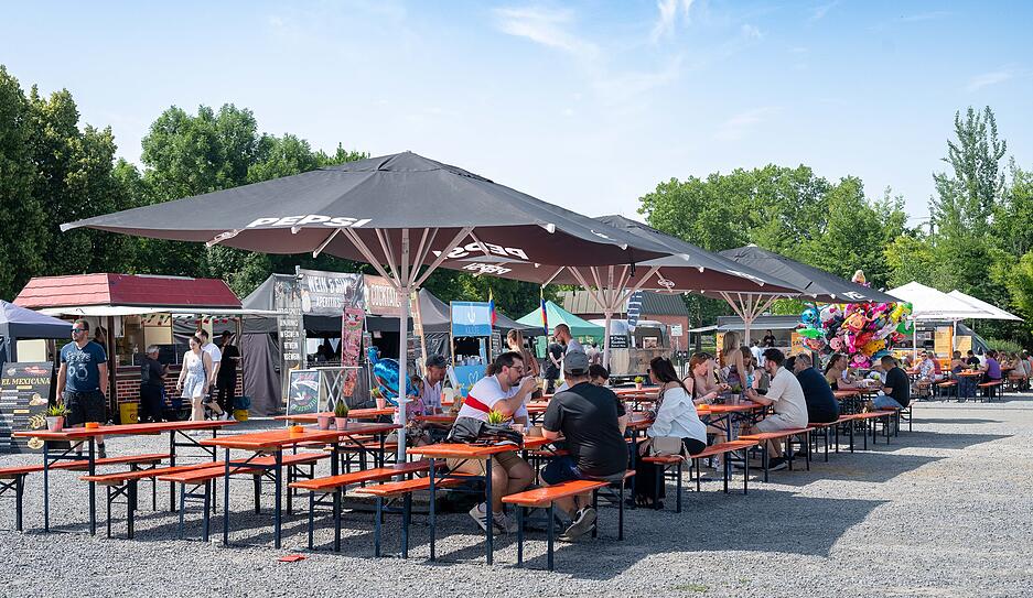 Beim Street Food Music Festival haben es sich die Besucher auf der Heilbronner Theresienwiese auf Bierbänken und unter Schirmen gemütlich gemacht.