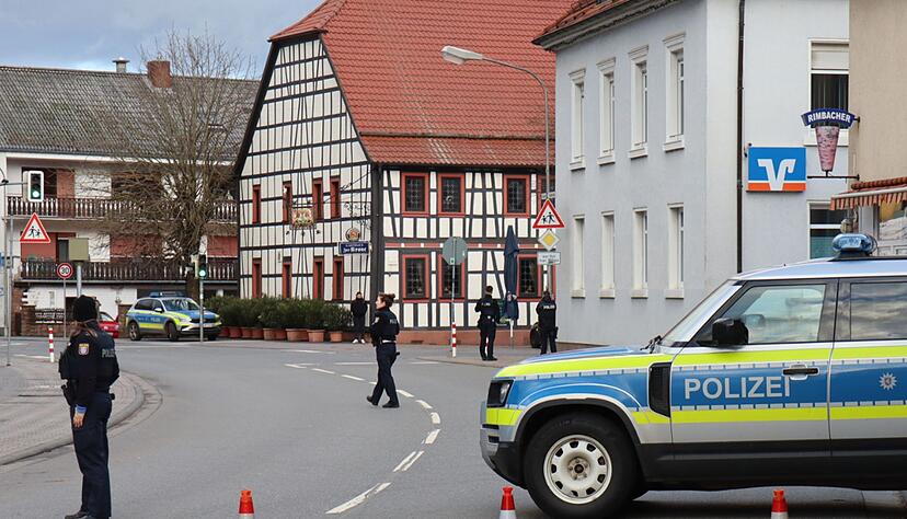 Polizeibeamte sichern die Stra&szlig;e rund um die Bankfiliale.