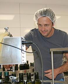 Betriebschef Stefan Kerner legt selbst an der Abfüllanlage Hand an. Anschließend werden die Flaschen etikettiert und können verkauft werden.