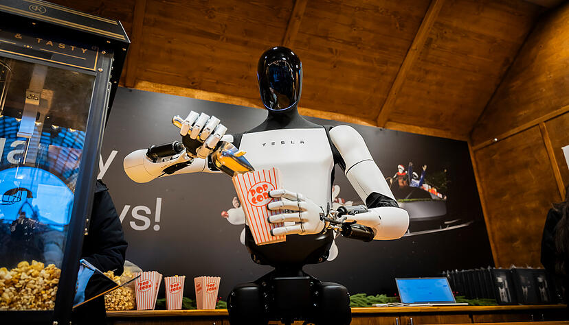 Der humanoide Roboter "Optimus" von Tesla verteilt bei seiner Vorstellung Popcorn. Tesla-Chef Musk will die Roboter bis Ende 2027 in den Verkauf bringen.