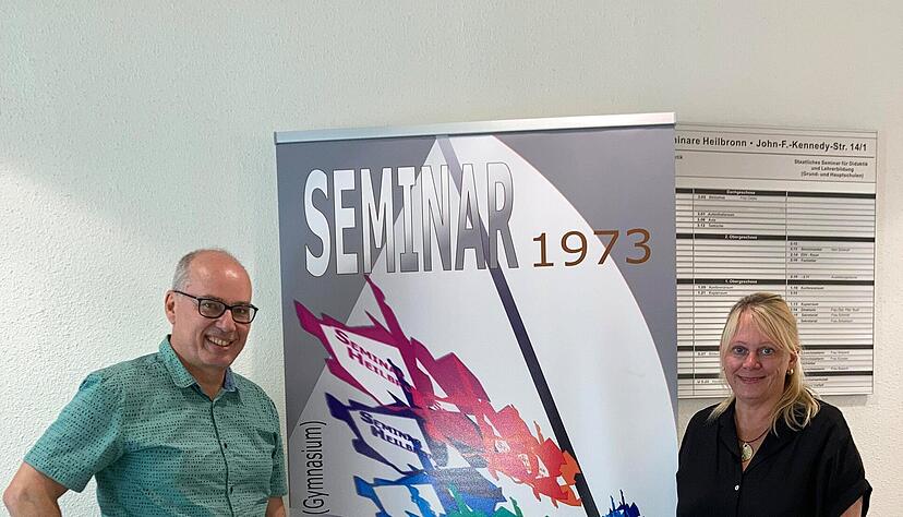 Martina Geiger und Karsten Wiese vor dem Plakat, das am Eingang des Geb&auml;udes zwischen Polizeirevier und Finanzamt-Au&szlig;enstelle auf das 50-j&auml;hrige Bestehen des Heilbronner Lehrerseminars aufmerksam macht.
Foto: Susanne Schwarzb&uuml;rger,
