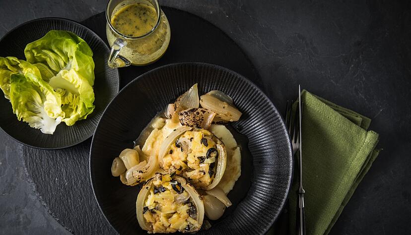 Diese vegetarische Variante einer gef&uuml;llten Zwiebel hat ein Innenleben aus Kartoffeln und Oliven. Serviert wird sie mit Kartoffelp&uuml;ree und Bratensud.