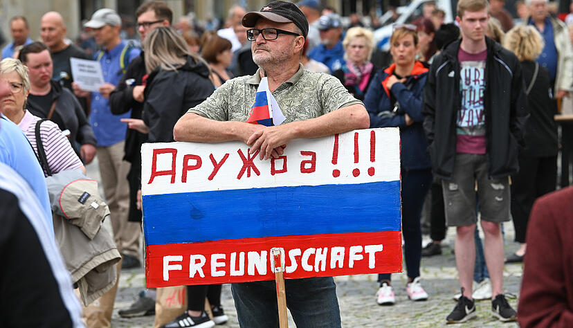 Ein Teilnehmer einer AfD-Kundgebung im Jahr 2023 h&auml;lt ein Schild in den Farben von Russland mit der Aufschrift &bdquo;Druschba!!! - Freundschaft&ldquo;. Der stellvertretende bayerische AfD-Vorsitzende Rainer Rothfu&szlig; gr&uuml;ndete den Verein &bdquo;Druschba-Global&ldquo;. Foto: dpa