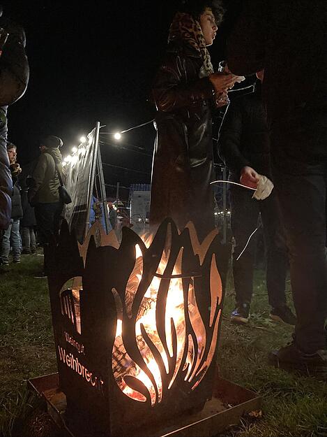Schwedenfeuer und Feuerkörbe sind von Menschen umringt.