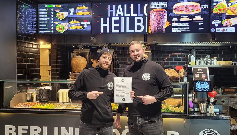 Merouane Mebarkaoui (links) und Igor Forisch mit dem Schild, das darum bittet, Obdachlose oder Menschen in Not zu ihnen zu schicken.