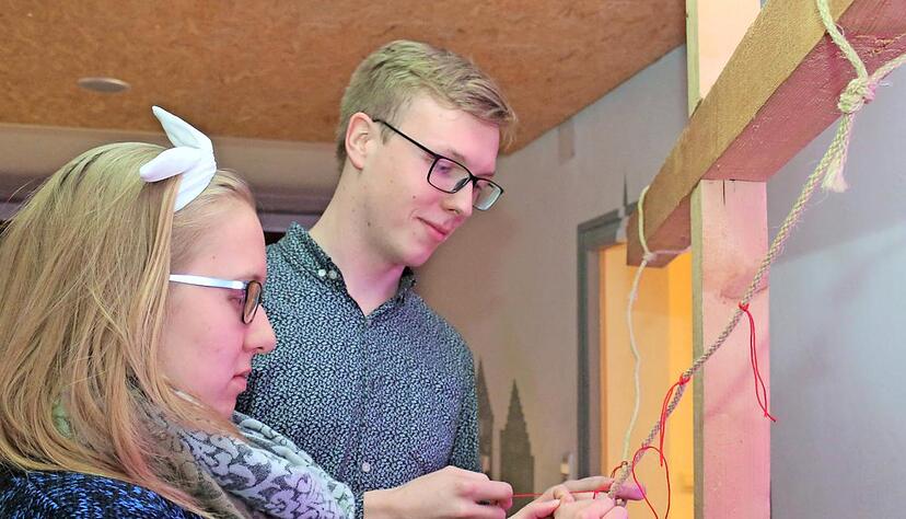 Mit ihrem roten Faden am symbolischen Christuskreuz zeigten auch Lena Reisigel und Marco Elischer, dass sie Teil eines Ganzen sind.Foto: Ute Plückthun,
