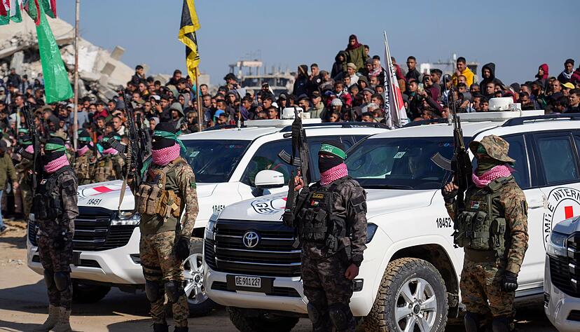 Islamisten umstellen Autos des Roten Kreuzes.