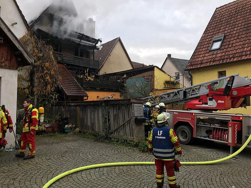 Blick von der Rückseite auf das brennende Gebäude: Dichte Rauchschwaden dringen aus den Haus.