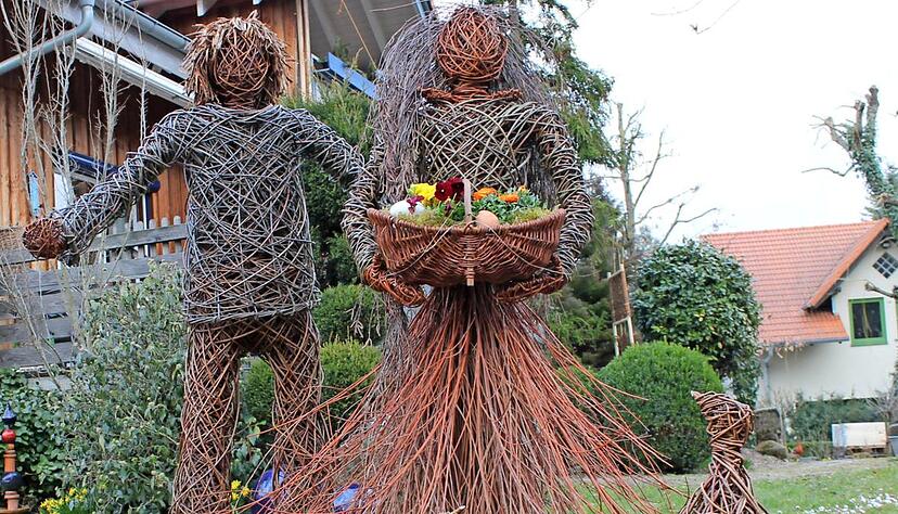 Gr&uuml;&szlig;en die Spazierg&auml;nger, die am Garten der Familie in Weiler vorbeilaufen: die Krippenfigur Josef und die Blumenfrau, erg&auml;nzt durch Federvieh.