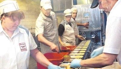 Hand in Hand am Förderband: Wenn das Essen fertig ist, wird es portioniert. Alles muss wie am Schnürchen klappen, damit es rechtzeitig an die Firmen, Sozialstationen und Schulen geliefert werden kann.Fotos: Guido Sawatzki Hand in Hand am Förderband: Wenn das Essen fertig ist, wird es portioniert. Alles muss wie am Schnürchen klappen, damit es rechtzeitig an die Firmen, Sozialstationen und Schulen geliefert werden kann.Fotos: Guido Sawatzki