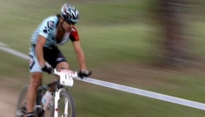 Ein Mountainbiker rast den abgesteckten Kurs entlang.