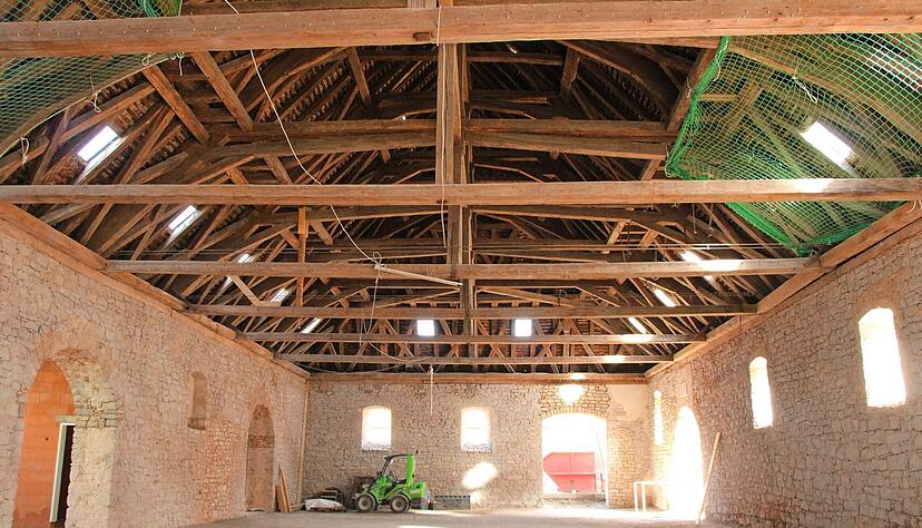 Das m&auml;chtige Geb&auml;lk und die von der Sonne in warmes Licht getauchten Natursteinw&auml;nde zaubern eine warme Atmosph&auml;re in die historische Kelter.