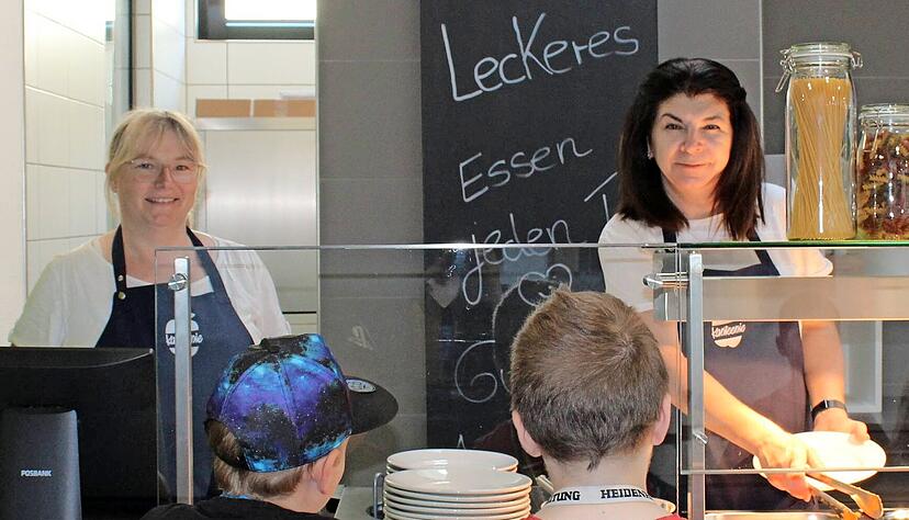 Freuen sich &uuml;ber neue Gesichter und "alte Hasen" in der Mensa: Claudia Lang (links) und Hakima Zecirovic geben das Essen an die Kinder aus der Kernzeit. Die Zahl schwankt je nach Wochentag stark.
Foto: Stefanie Jani