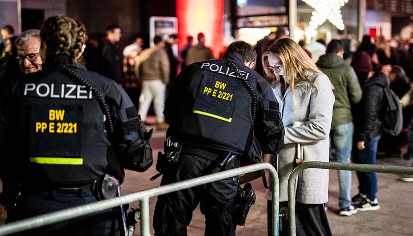 Polizisten kontrollieren am Silvesterabend Menschen am Schlossplatz. Polizisten kontrollieren am Silvesterabend Menschen am Schlossplatz.