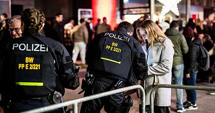 Polizisten kontrollieren am Silvesterabend Menschen am Schlossplatz.