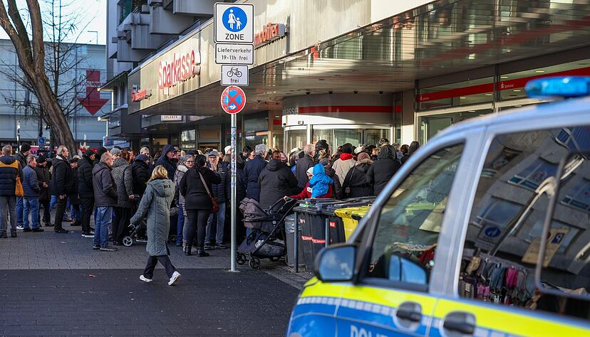 Polizisten sichern den Eingang der Sparkassenfiliale in Gelsenkirchen-Buer, nachdem wartende Kunden versucht hatten in die Bank zu gelangen.