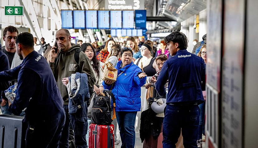 Reisende stehen Schlange am Serviceschalter der Fluggesellschaft KLM&nbsp;am Flughafen Schiphol.