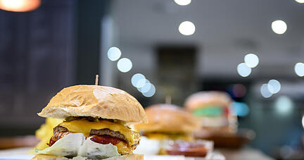 Ein Cheeseburger steht in einem Fast-Food-Restaurant auf dem Tresen. Foto: dpa