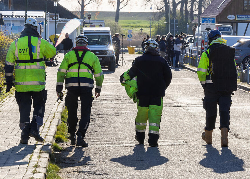 Mitarbeiter einer Bergungsfirma gehen am Morgen zu einer Besprechung und weiteren Planung in den Hafen auf der Insel Poel.