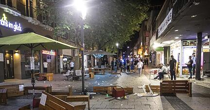 Tische und Bänke liegen nach der Randale in der Stuttgarter Innenstadt auf dem Pflaster.
