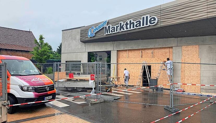 Handwerker verblenden den zerstörten Eingangsbereich der Offenauer Markthalle.