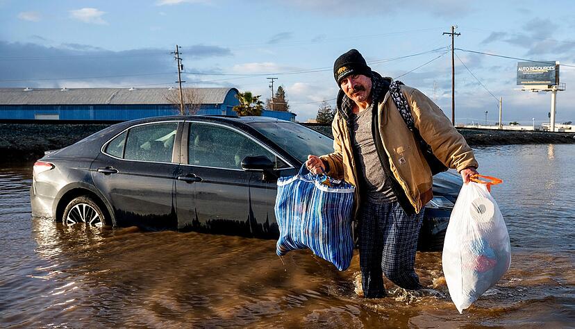 Ein Mann trägt im Januar in Merced, Kalifornien, Habseligkeiten aus seinem überfluteten Haus.