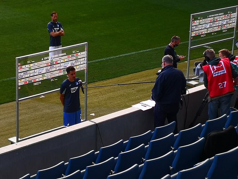 Sicherheitsabstand: Der TV-Sender Sky interviewt mit einer langen Mikrofon-Angel von der Trib&uuml;ne aus