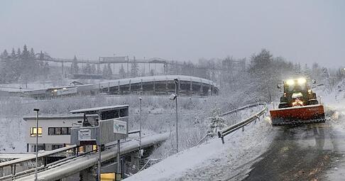 Ein Räumfahrzeug streut die Fahrwege an der Bobbahn.