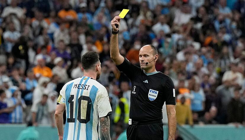 Weniger Gefahr f&uuml;r eine Gelbsperre: Hier wird Argentiniens Lionel Messi (l) bei der WM 2022 von Schiedsrichter Antonio Mateu Lahoz verwarnt. (Archivbild)