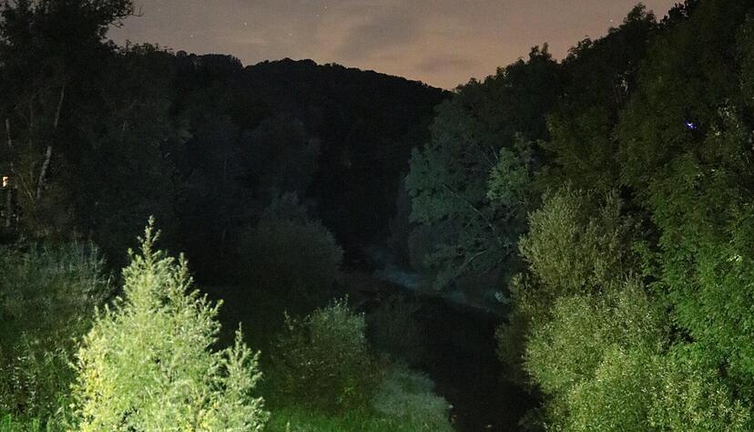 In Buchenbach leuchten nachts die Straßenlaternen auf der Brücke, hier macht sich die Jagst auf den Weg durch den Hohenlohekreis.