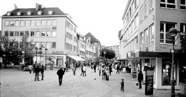 Fußgängerzone 2005: Blick vom Kiliansplatz in die Fleiner Straße zur Galeria Kaufhof am Standort des ehemaligen Merkurs im Hintergrund. Rechts eine Reklametafel, die auf die Geschäfte in der Kirchbrunnenstraße hinweist.