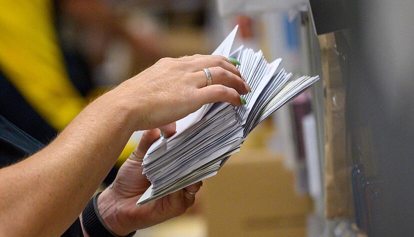 Eine Mitarbeiter der Deutschen Post sortiert in einem Zustellstützpunkt der Post Briefe. Eine Mitarbeiter der Deutschen Post sortiert in einem Zustellstützpunkt der Post Briefe.