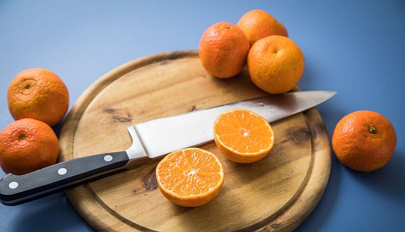 Schritt 1: Clementine mit einem Messer quer aufschneiden und halbieren.