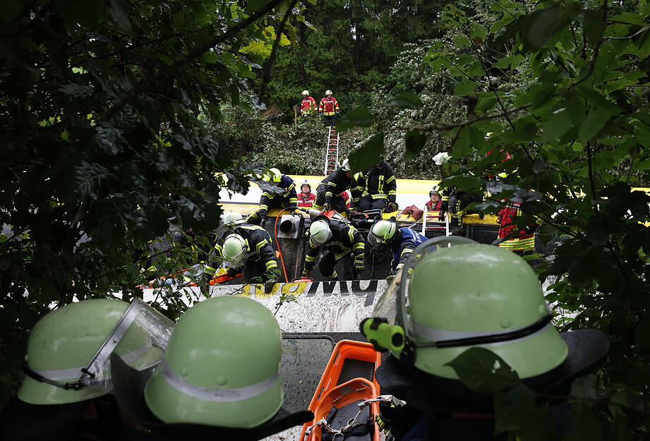 Rettungskräfte suchen in einem entgleisten Zug nach Fahrgästen.