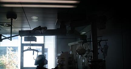 Eine Mitarbeiterin der Pflege steht in einem Zimmer einer Corona-Intensivstation.